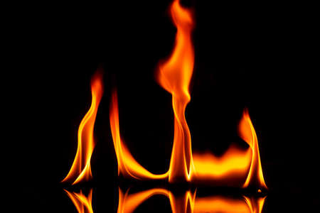 Fire with reflection on a dark background.の写真素材