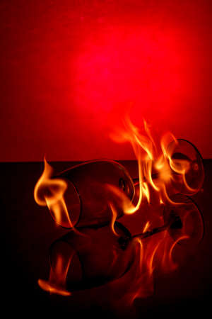 Crystal goblet with a drink on fireの写真素材