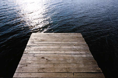 Wooden bridge on the lake in the sun