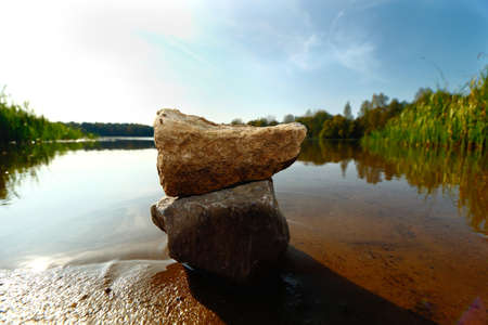 Stones on the lake against the skyの写真素材