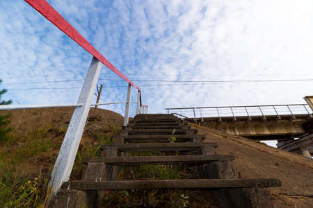 Wooden stairs on the bridge against the sky