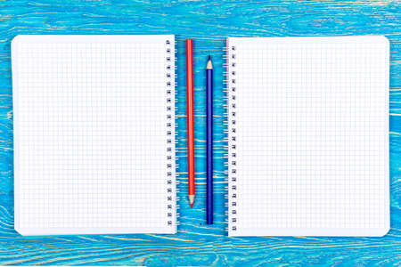 Notebooks and colored pencils on a wooden table. Design. Art. Background