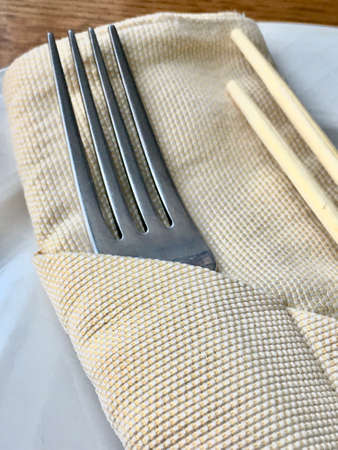 fork and wooden sticks on a plate in a restaurant