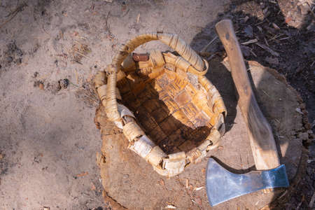Homemade basket and axe on a stump in the forestの写真素材