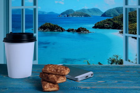 Paper coffee cup, biscuits and telephone on a wooden tableの写真素材