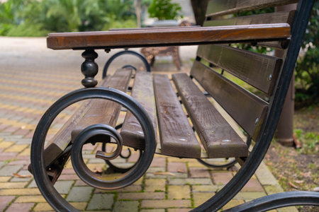 Wooden bench with twisted legs in the park