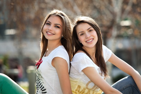 two friends, happy, young women in the parkの写真素材
