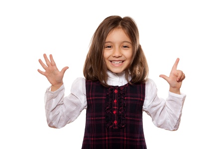 portrait of a lovely little girl, smiling, showing seven items, dressed in school uniform, isolated on white backgroundの写真素材
