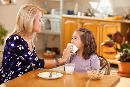 mother and daughter having breakfast: milk and cerealsの写真素材