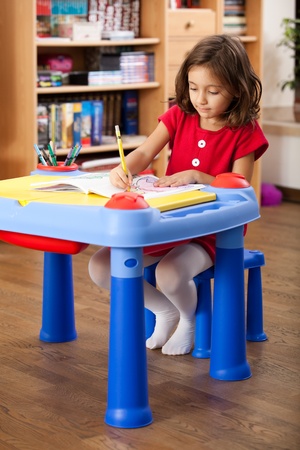 little girl drawing on her book at playtableの写真素材