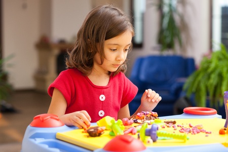 lovely little girl playing with plasticine on her playtableの写真素材