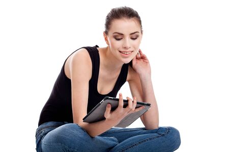portrait of a beautiful, teen girl, using a tablet, isolated on white backgroundの写真素材