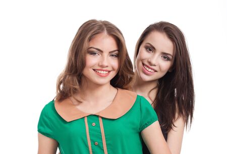 two teenage girls, smiling, isolated on white backgroundの写真素材