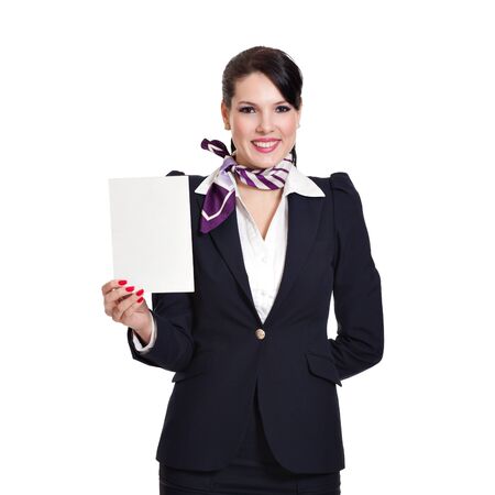 Beautiful dark haired young business woman dressed in a navy suit with a purple scarf holding a blank sheet of cardboard in her right hand, isolated on white backgroundの写真素材