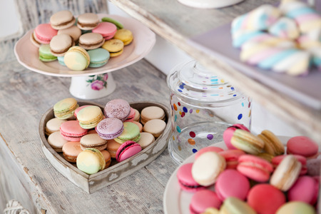 Coloured arrangement of macaroons and marshmallows on a wooden tableの写真素材
