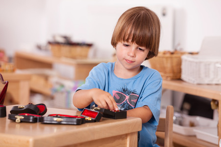 Child playing with musical instruments toys at his table; Image shot from a kindergartenの写真素材