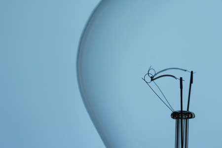light bulb filament on blue backgroundの写真素材