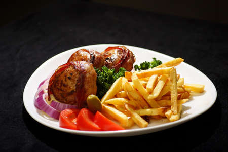turkey medallion stuffed with kymac cheese and bacon served with french fries  and green vegtablesの写真素材