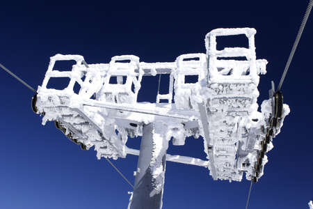 ski lift machinery covered with ice and snowの写真素材
