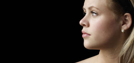 young woman with diamond and opal earings black backgroundの写真素材