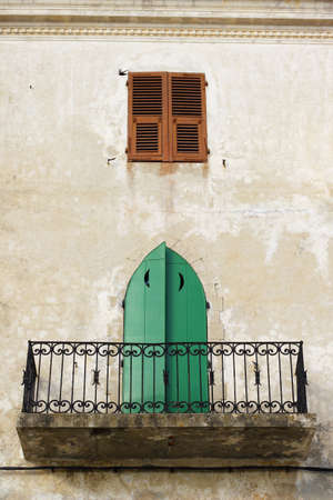 a traditional, town house balcony and old wood door in Calvi Corsica の写真素材