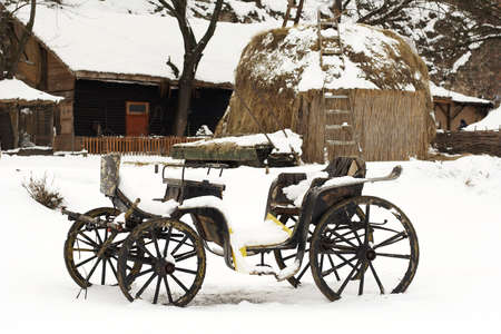an old horse drawn carriage in the snowの写真素材
