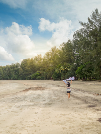 Girl on the beach, sandy beach and sea, green trees with blue sea and beautiful beaches.の写真素材