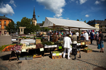 S?ERT?JE, SWEDEN - JULY 19, 2012: Main Square in S?t?e with the church in the background and vegetable sales in the foreground on the farmerのeditorial素材