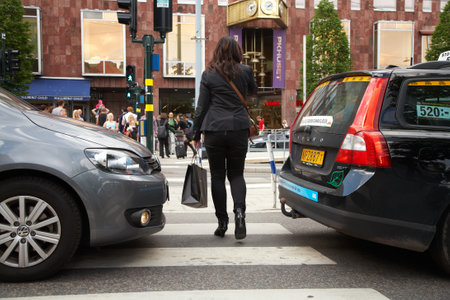 STOCKHOLM, SWEDEN - JUNE 20, 2012: Congestion at a pedestrian crossing with traffic signals on Hamngatan in Stockholm.のeditorial素材