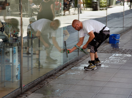 SODERTALJE, SWEDEN - July 20, 2012:  A man cleaning the windows of the shop window to the store Kringlan in S?t?e.のeditorial素材