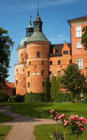 Part of Gripsholm Castle with a tower and park in Mariefred, Sweden. The castle is a royal palace built during the 1500s and is today a popular tourist destination.のeditorial素材