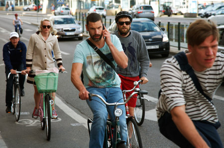 Stockholm, Sweden - June 20, 2012: A male cyclist without a helmet, talking on a mobile telephone among cyclists in traffic on tSkeppsbron  in Stockholm. Such like behavior results in less attention to traffic, which increases the risk of accidents.のeditorial素材