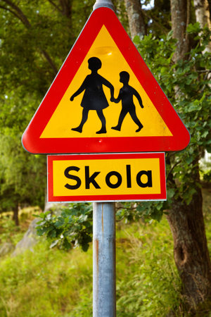 Swedish road sign warning for children, with the sign, which clarifies that there is a school nearby.のeditorial素材