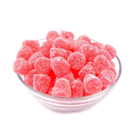 Jelly Raspberry gumdrops filling a glass bowl on a white background  の写真素材