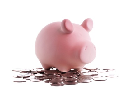 One pink piggy bank and coins isolated on white background の写真素材