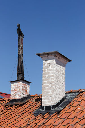 Two older chimneys on a rooftop.の写真素材