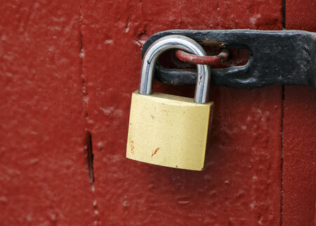 Locked padlock on red door.の写真素材