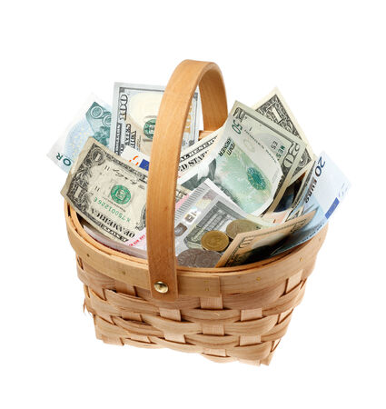 Basket filled with money in different currencies isolated on white background.の写真素材