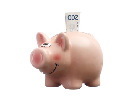 Pink piggy bank with a Norwegian 200 kroner bank note, isolated on white backgound.の写真素材
