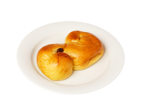 Typical Swedish saffron bun \\\"lussekatt\\\" eaten in conjunction with the Lucia celebrations and Christmas celebrations served on a small white plate..の写真素材