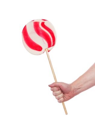 Hand holding a large candy cane lollipop isolated on white background.の写真素材