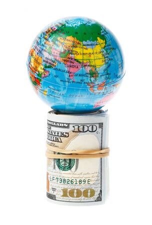 The world supported by a roll of US 100 Dollars bills, isolated on white.の写真素材