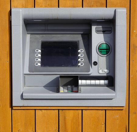 A ATM mounted in a yellow wooden wall.の写真素材