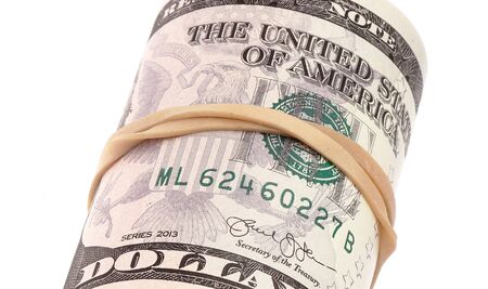 Close up pf rubber band wrapped roll with five dollars banknotes on white background.の写真素材