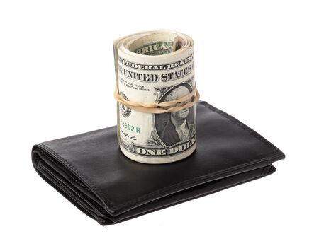 One roll with oneUS  dollar banknotes on top of a black wallet isolated on white.の写真素材