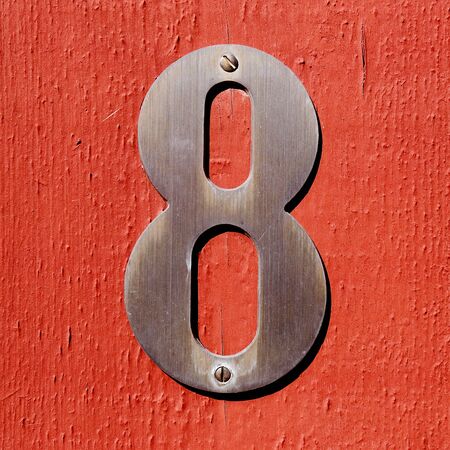 Number eight isolated on a red wooden wall.の写真素材