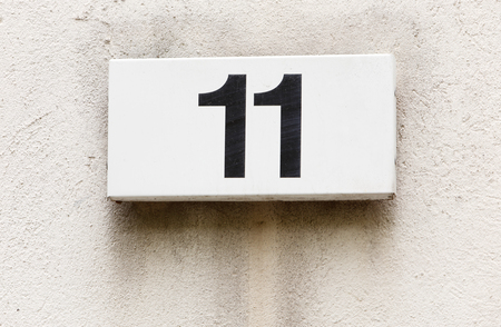 Number eleven on a white plate attached to a buildings exterior wall.の写真素材