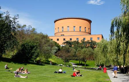 Stockholm, Sweden - August 6, 2015: The Stockholm public library located at street Sveavagen with park wit people sitting on the lawn in the foreground. Construction began 1924 and the library was opened in 1928.  Architect was Gunnar Asplund.のeditorial素材