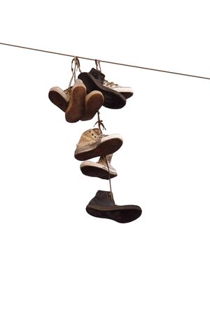 Shoes hanging on wire isolated on white background.の写真素材