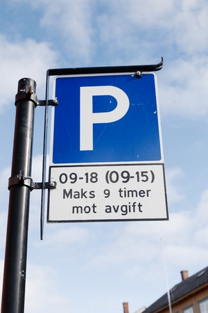 Norwegian parking sign with additional plate with parking rules. Parking fee 9-18 working days and 9-15 on Saturdays.の写真素材